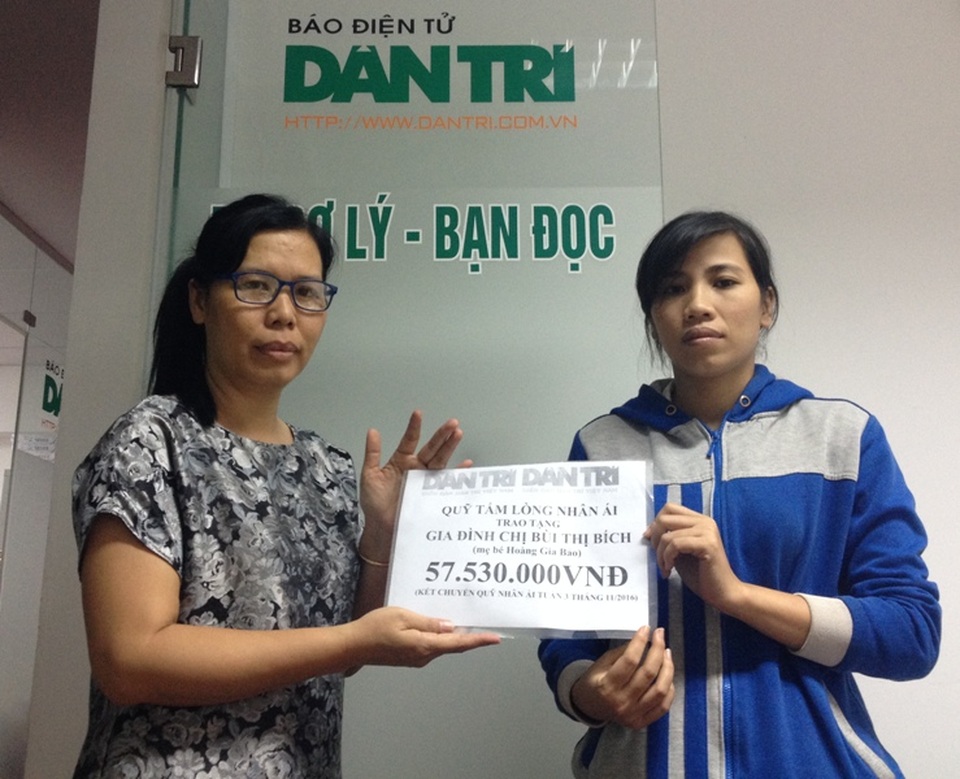 Nhà báo Lý Thị Toàn Thắng (trái) - Trưởng văn phòng đại diện Phía Nam, trao quà tặng của bạn đọc đến chị Bùi Thị Bích (mẹ bé Hoàng Gia Bảo)