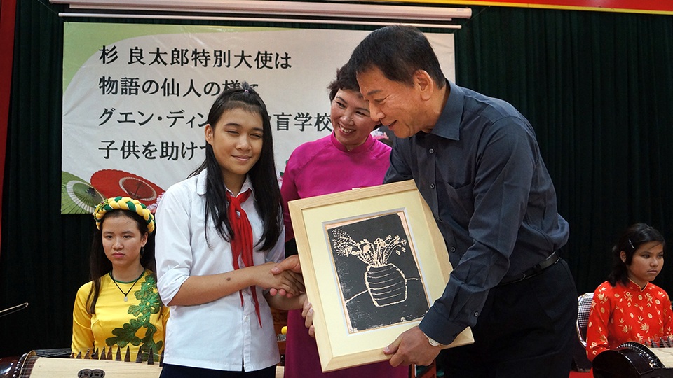 
Ông vui vẻ và xúc động nhận món quá là bức tranh từ tay của học sinh khiếm thị.
