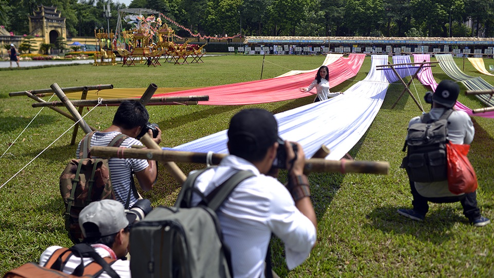 Những tay máy với ống kính máy móc lỉnh kỉnh đang sáng tác cho một thiếu nữ áo dài xinh xắn bên những dải lụa đầy sắc màu của làng nghề truyền thống lụa Vạn Phúc - Hà Đông.