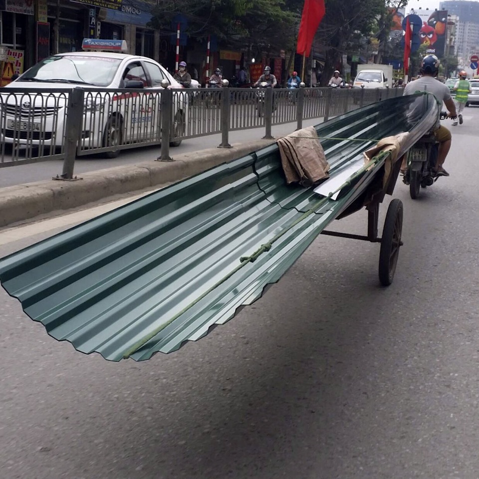 Xe tự chế chở hàng quá khổ vẫn hoành hành ở Hà Nội - 4 Những tấm tôn kích thước lớn được chở bằng phương tiện tự chế đi trên đường.