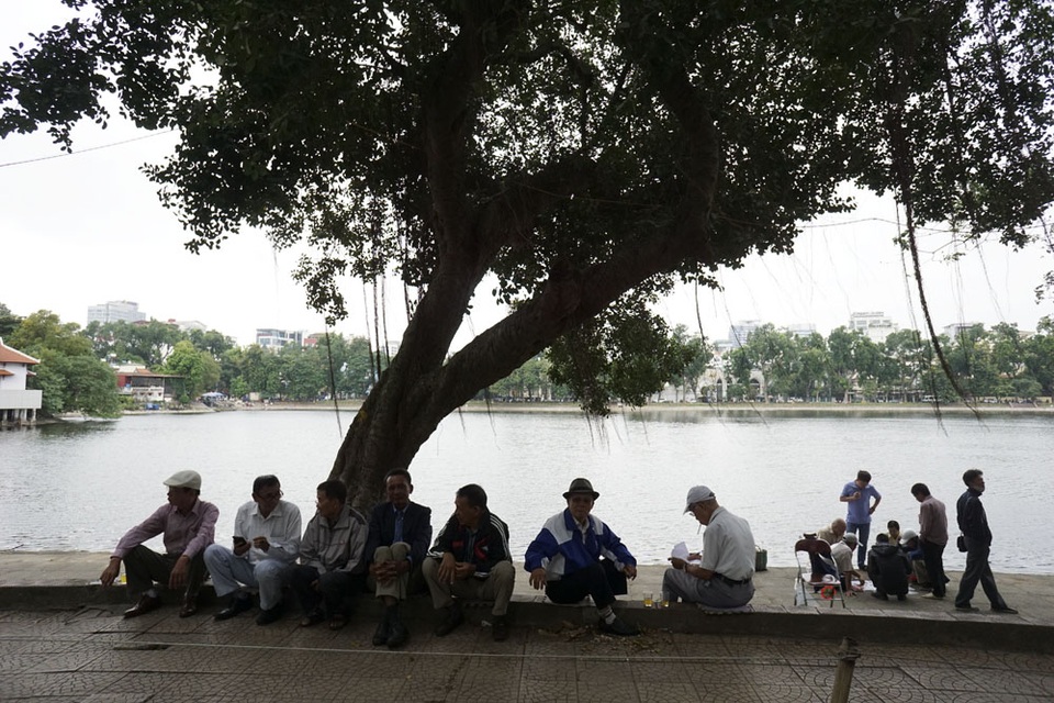 Hà Nội chuyển lạnh đầu đông - 10 Một nhóm người cao tuổi với áo rét đang nghỉ ngơi bên hồ Thiền Quang.
