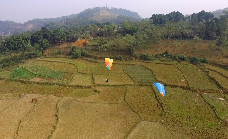 Cô dâu chú rể đáp dù lượn tới... đám cưới trên cánh đồng Hà Nội - 2 Cô dâu Hải Yến và chú rể Tuấn Dũng đều là những người trẻ, yêu thích dù lượn nên đã nảy ra ý tưởng đáp dù lượn đến đám cưới. Hầu hết quan khách của đám cưới cũng dùng dù lượn đến tham dự.