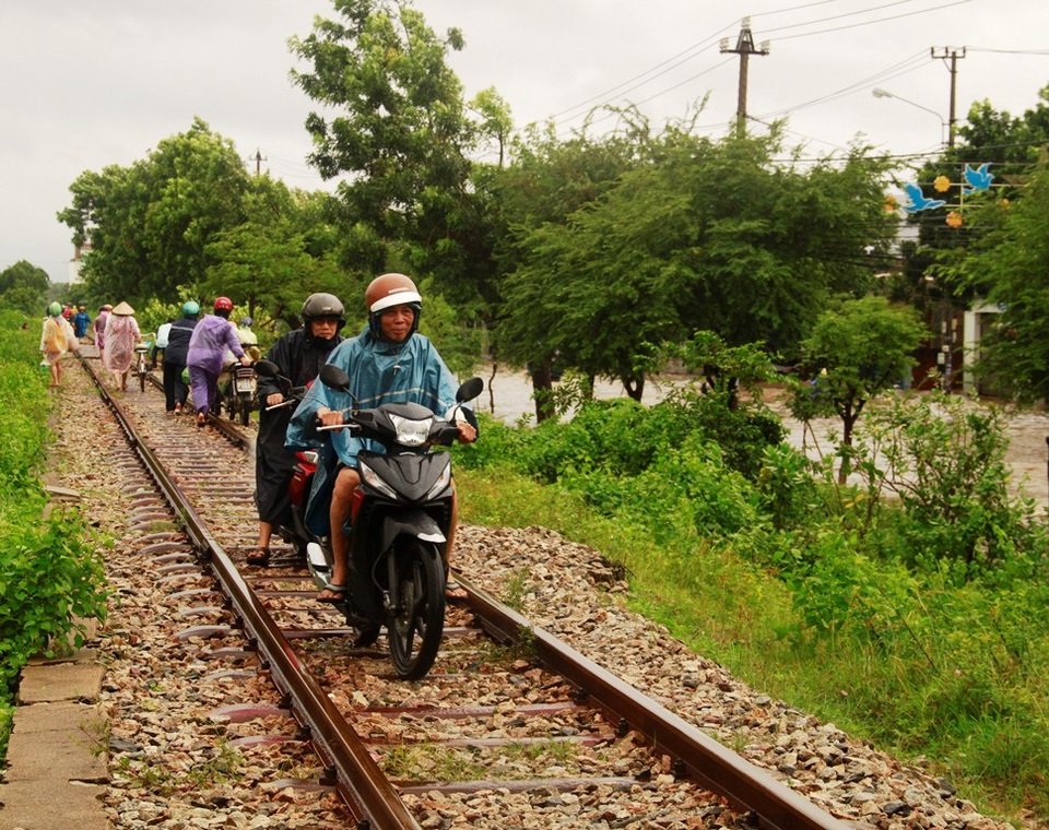 Đường bộ bị ngập người dân đi trên đường ray xe lửa