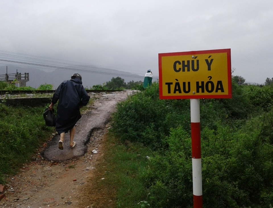 Thót tim cảnh dân cuống cuồng chạy tàu khi tránh lũ trên đường ray - 2 Dù có biển cảnh báo tàu hỏa nhưng do ngập lụt người dân buộc lòng đi trên đường ray tàu hỏa
