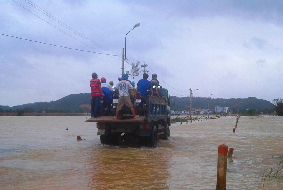 “Hốt bạc” nhờ vận chuyển xe và người vượt lũ… - 4 Xe máy và người được đưa lên xe tải băng qua tràn Huỳnh Mai trong nước lũ