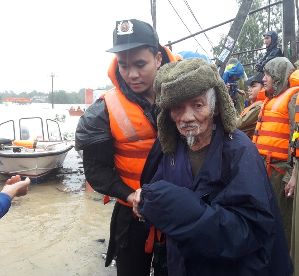 Lực lượng cứu hộ di dời một cụ ông ở thị xã An Nhơn (Bình Định) do nước ngập vào nhà hơn 1 mét