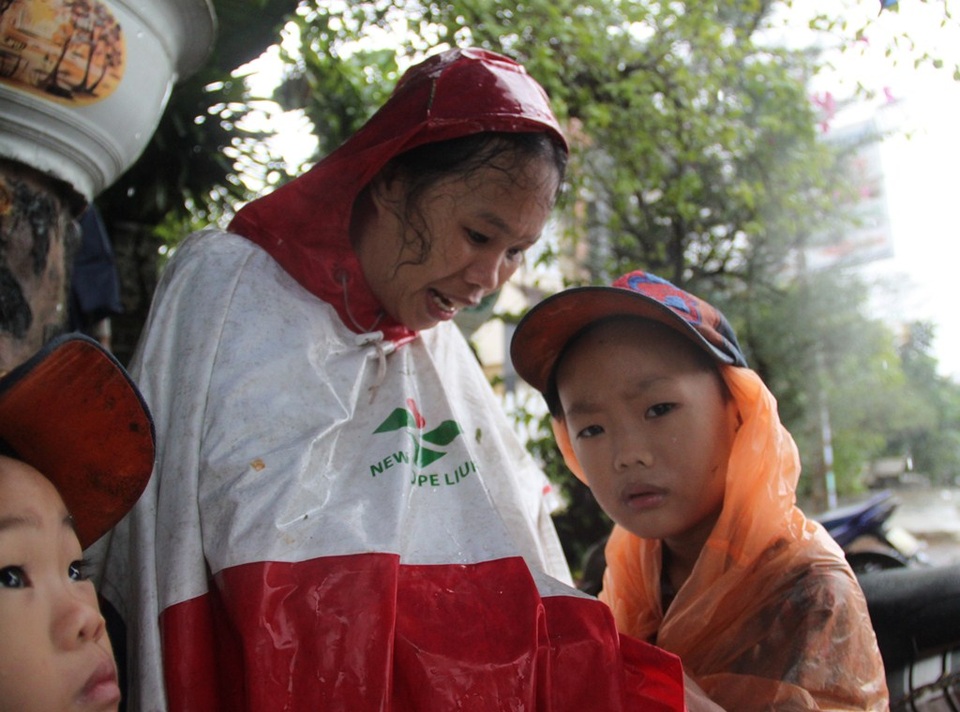 Lực lượng cứu hộ đưa 3 mẹ con chị Nhì (ở huyện Tuy Phước) thoát khỏi vùng lũ dữ