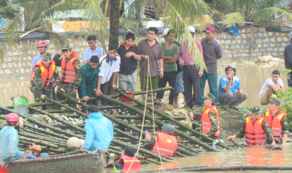 200 chiến sĩ vật lộn với dòng nước lũ, trục vớt tàu cá - 3 Các chiến sĩ bộ đội, công an ngâm mình trong lòng nước lũ đưa bè cá để khơi thông dòng chảy qua cầu Thiện Chánh
