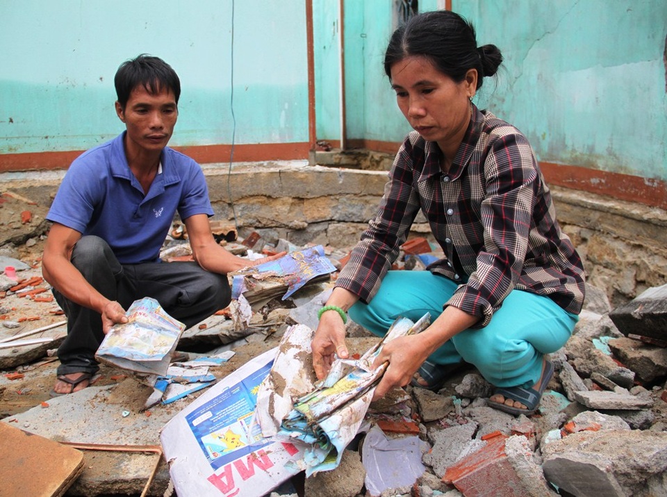 
Nhà sập, hồ tôm mất trắng, sách vở con cái vùi trong đống đổ nát khiến vợ chồng anh Phan Văn Long và chị Phạm Thị Lâm (42 tuổi, trú xã Mỹ Chánh, huyện Phù Mỹ, Bình Định) thẫn thờ.
