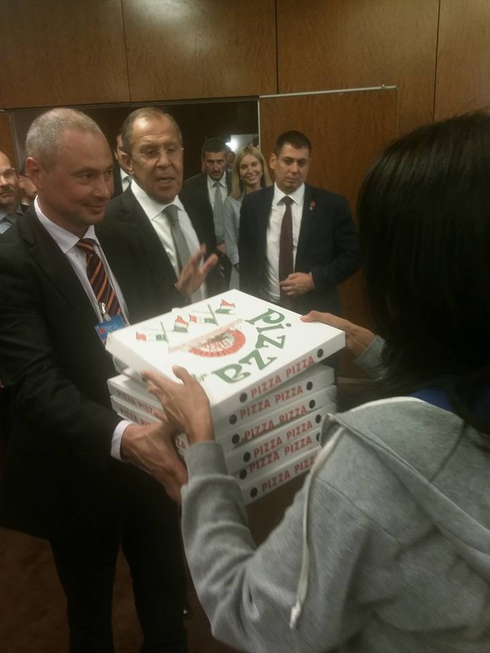 Món quà xin lỗi bất ngờ của Ngoại trưởng Mỹ dành cho phái đoàn Nga - 1 Ngoại trưởng Nga Sergey Lavrov (giữa) mang pizza chia cho các phóng viên bên ngoài phòng họp (Ảnh: Facebook)