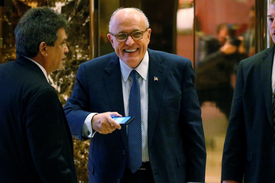 Cựu Thị trưởng New York, Rudy Giuliani, đang được đồn đoán là người sẽ nắm giữ vị trí Ngoại trưởng trong nội các của ông Trump sau khi ông tiếp quản Nhà Trắng vào ngày 20/1 tới. Trong ảnh: Ông Giuliani tươi cười với các phóng viên tác nghiệp trong Tháp Trump.