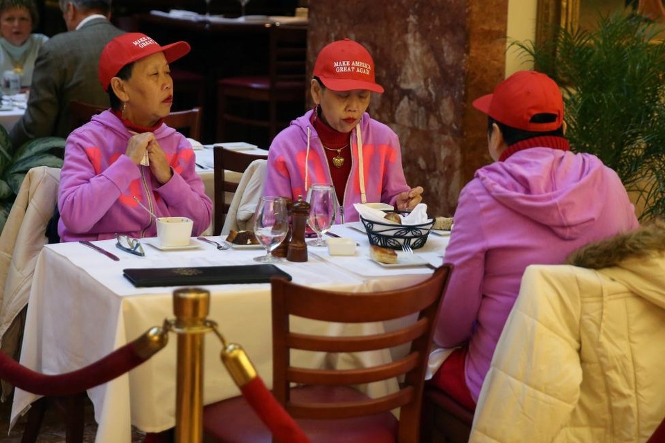 
3 phụ nữ ủng hộ ông Trump, đội mũ có ghi khẩu hiệu tranh cử của ứng viên tổng thống đảng Cộng hòa là “Đưa nước Mỹ vĩ đại trở lại”, ngồi ăn tại một cửa hàng bên trong Tháp Trump.
