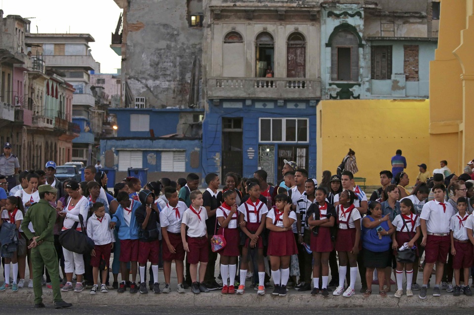 Các em học sinh nhìn theo đoàn xe chở tro cốt lãnh tụ Fidel Castro ở thủ đô Havana.