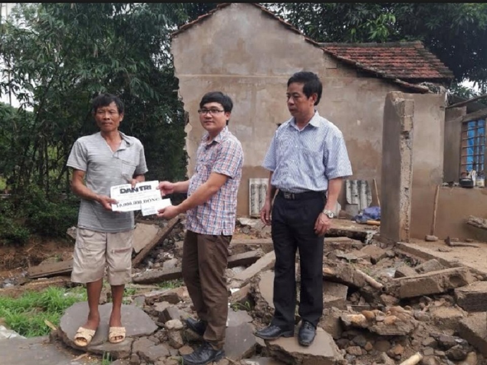 Quỹ Nhân ái hỗ trợ nóng 20 triệu đồng đến hai gia đình bị sập nhà trong mưa lũ - 3 Ông Cao Xuân Tín, Phó Chủ tịch UBND huyện Tuyên Hóa và PV Dân trí tại Quảng Bình trao tiền hỗ trợ cho gia đình anh Phan Đình Du. (Ảnh Đặng Tài)
