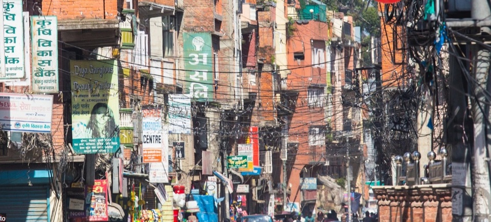 Một con phố đông đúc ở thành phố Kathmandu, Nepal. Dù bức ảnh không có bóng người, nhưng chỉ cần nhìn lên tầng không cũng đủ hình dung ra quang cảnh bên dưới, với những bó dây điện nhằng nhịt và những biển quảng cáo chen chúc, tranh nhau ánh nhìn của người qua đường.
