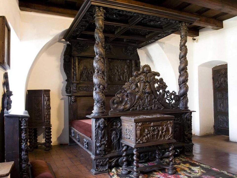 Phòng ngủ với chiếc giường cổ được chạm trổ cầu kỳ.