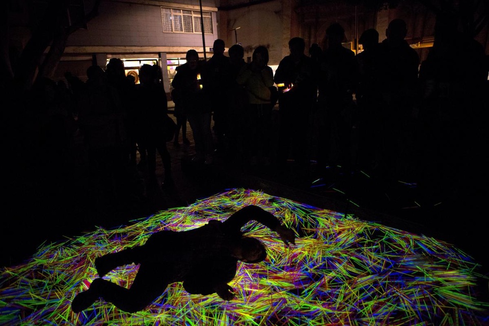 Một người đang đùa nghịch với những thanh phát sáng trong một sắp đặt tương tác nghệ thuật nằm ở trung tâm thành phố Mexico.