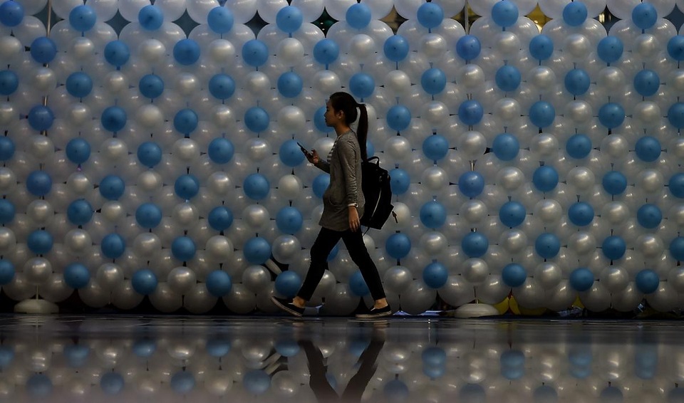 Cô gái đi ngang qua “bức tường bóng bay” được dựng lên trong một siêu thị ở Kuala Lumpur, Malaysia.