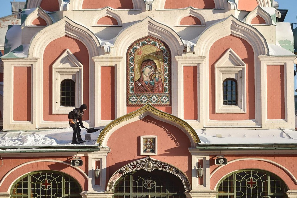 Một người đàn ông đang xúc tuyết khỏi mái của một nhà thờ nằm trên quảng trường Đỏ ở Moscow, Nga. Thời điểm này nhiệt độ có lúc xuống tới -13 độ C.