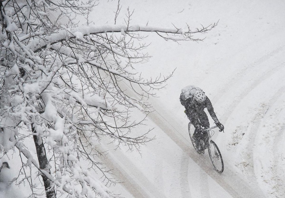 Một người đàn ông đạp xe trong cơn bão tuyết ở Stockholm, Thụy Điển.