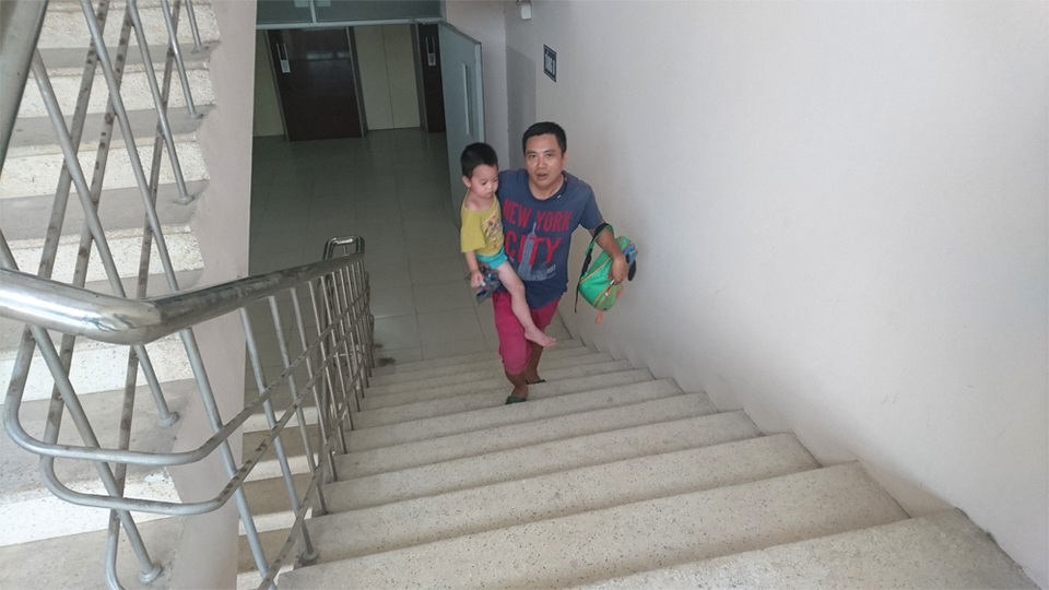 Hà Nội: Dân tái định cư “tái mặt” vì leo cầu thang hàng chục tầng - 4 Anh Du vất vả bế con leo cầu thang bộ lên tầng 8.