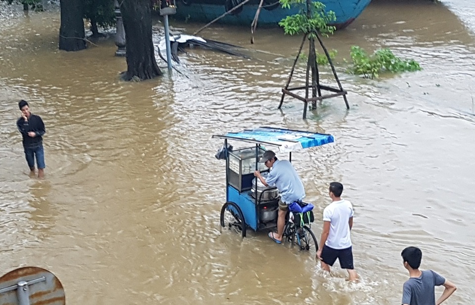 Xe bánh bao cố gắng vượt qua dòng nước lũ để đi bán mẻ bánh mới ra lò lúc chiều