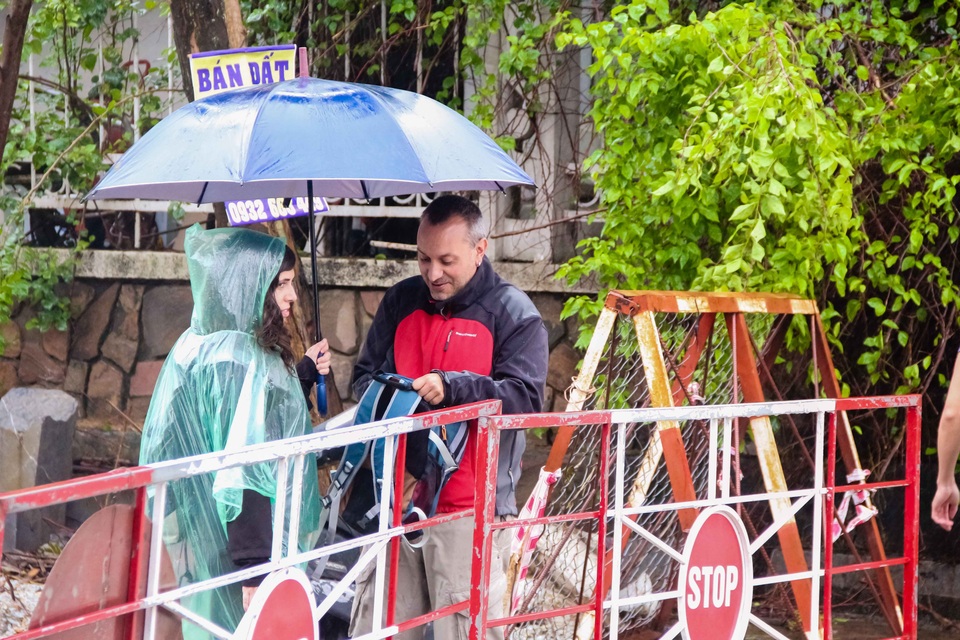 Hai du khách Tây chụp ảnh dòng nước lũ chảy xiết ở bến Đập Đá.