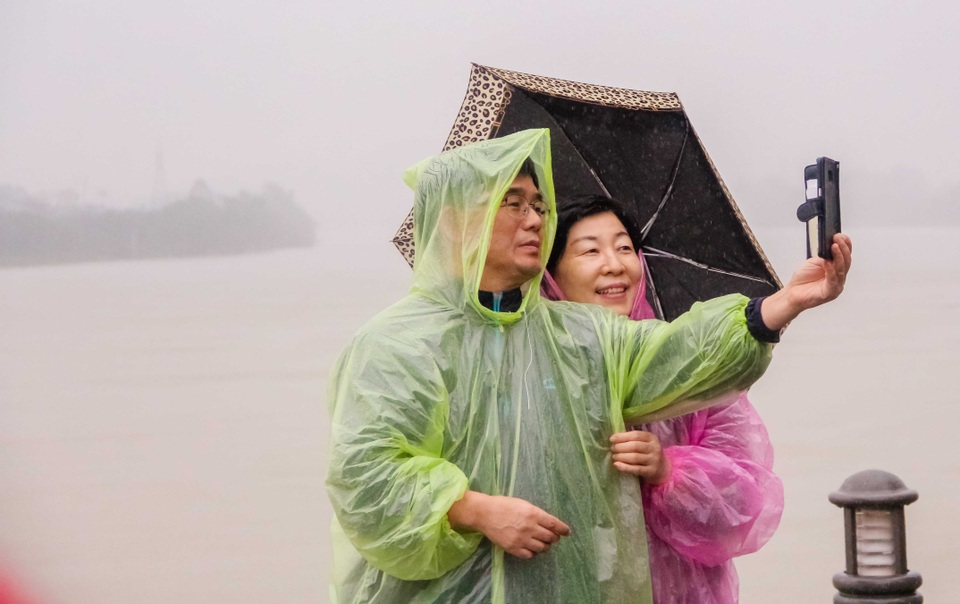 Đôi vợ chồng người Hàn Quốc cùng chụp bức ảnh kỷ niệm trong chuyến du lịch tại Huế đúng vào ngày trời lụt