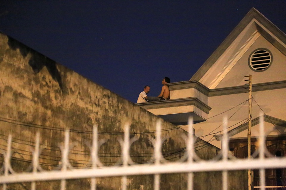 
Một cán bộ tiếp cận thanh niên thuyết phục xuống dưới.
