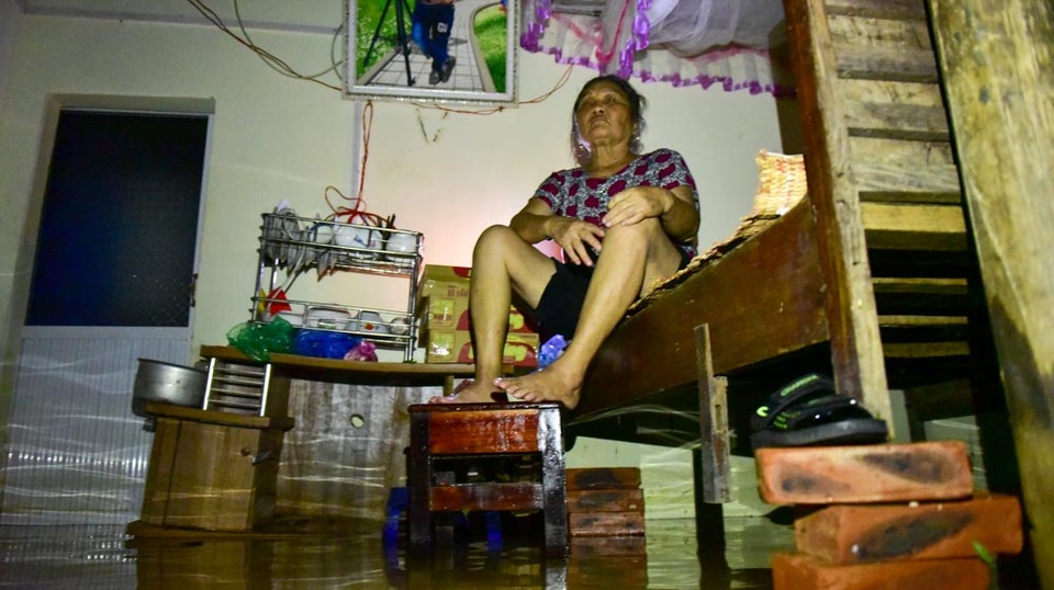 Dân vùng ngập Hà Nội: Ăn cơm dưới đèn dầu, nhà lênh láng nước - 3
Dù nước đã bắt đầu rút nhưng nhà bà Nghi vẫn còn ngập, đồ đạc phải kê cao trên nền nhà lênh láng nước. Thời điểm nước lũ tràn về mấy hôm trước, bà cũng phải đi sơ tán, đến nay nước rút mới trở về nhà.