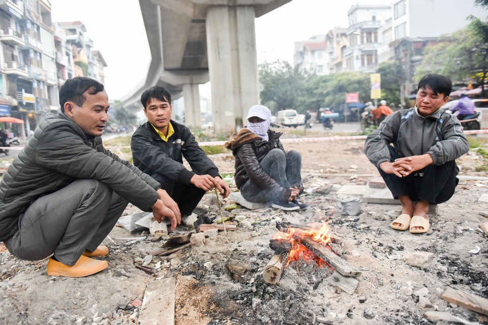 Người dân Hà Nội đốt củi sưởi ấm trên đường trong ngày mưa rét - 1
Một nhóm người làm nghề lao động tự do trên đường Hào Nam (Quận Ba Đình, Hà Nội) ngồi quây bên đống lửa. Do đặc thù của công việc, những lao động tự do ở đây thường xuyên phải ở ngoài trời.
Hôm nay, Hà Nội có mưa phùn, cảm giác thời tiết lạnh hơn những hôm trước.