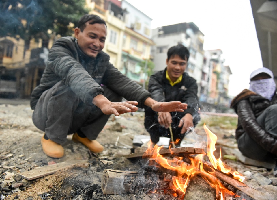 Người dân Hà Nội đốt củi sưởi ấm trên đường trong ngày mưa rét - 3
Trong thời gian chờ việc, họ quây quần cùng nhau bên đống lửa, nói dăm ba câu chuyện cũng xua bớt phần nào cái giá buốt.