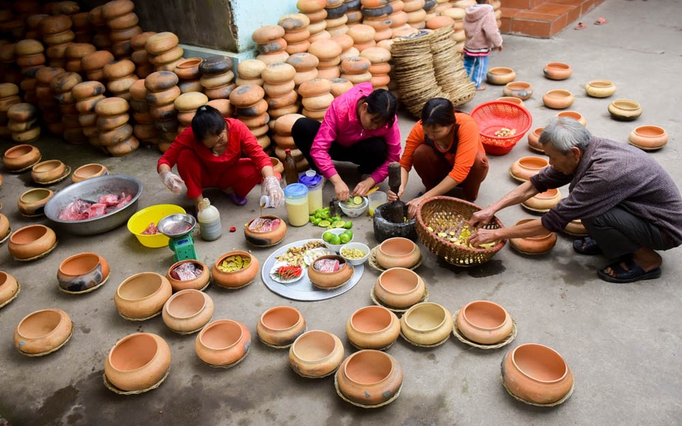 Cá kho làng Vũ Đại nhộn nhịp vào vụ Tết - 4
Niêu đất sau khi luộc sạch được lót một lớp riềng nát ở bên dưới để cá không bị cháy, rồi đến sườn lợn và cá.