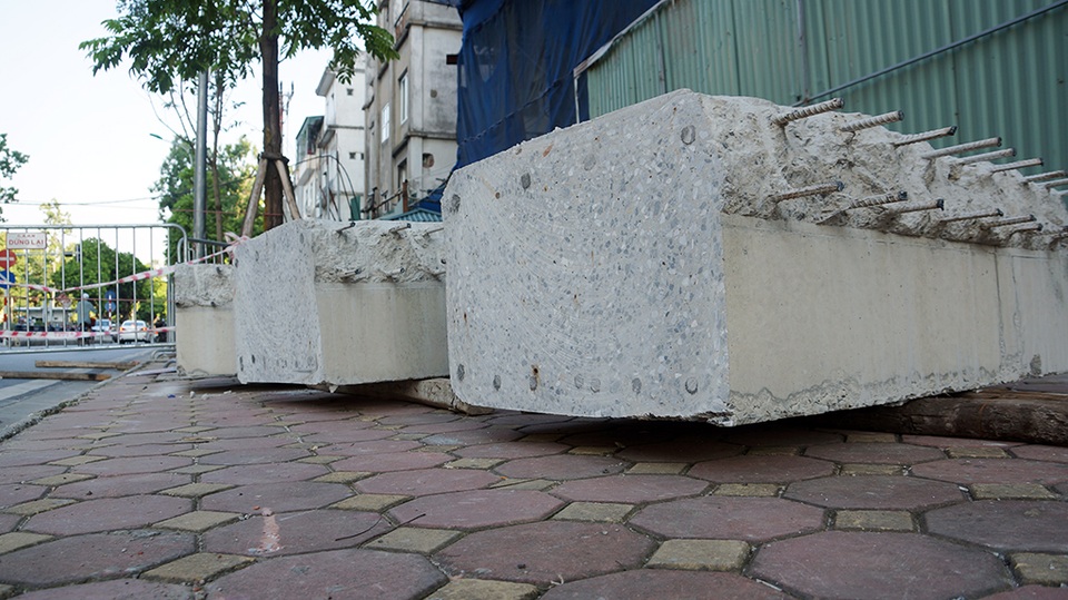 Từng khúc dầm bê tông được vận chuyển bằng cẩu trục tháp xuống đất.