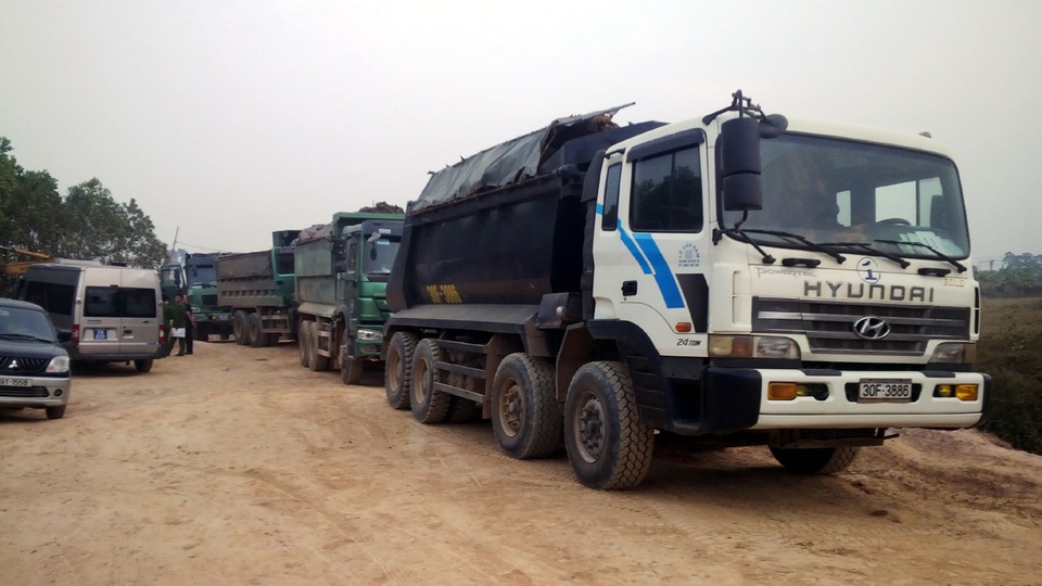 Khai thác trái phép hàng triệu mét khối đất sát sân bay Nội Bài - 4 Nhiều xe tải chở đất bị tạm giữ để làm rõ.