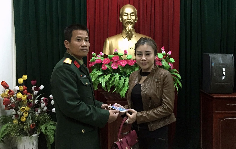 Trung úy Hà Văn Kiên trao trả chiếc điện thoại bị cướp cho chị Quỳnh Anh.