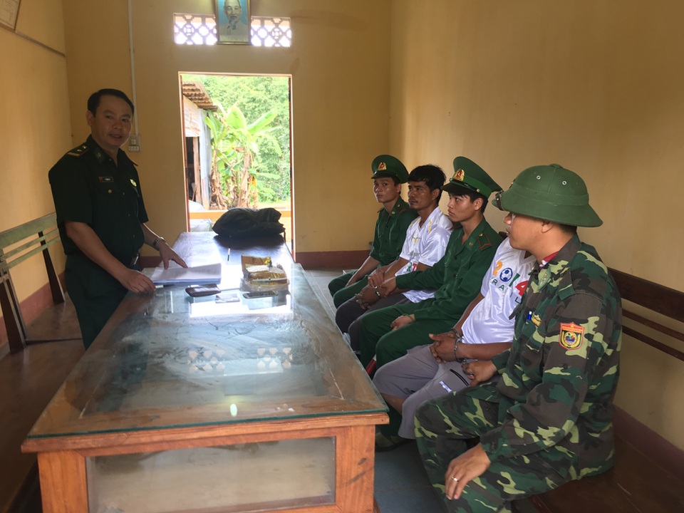 2 đối tượng (áo trắng, ngồi xen giữa) đang bị cơ quan chức năng tạm giữ chờ xử lý