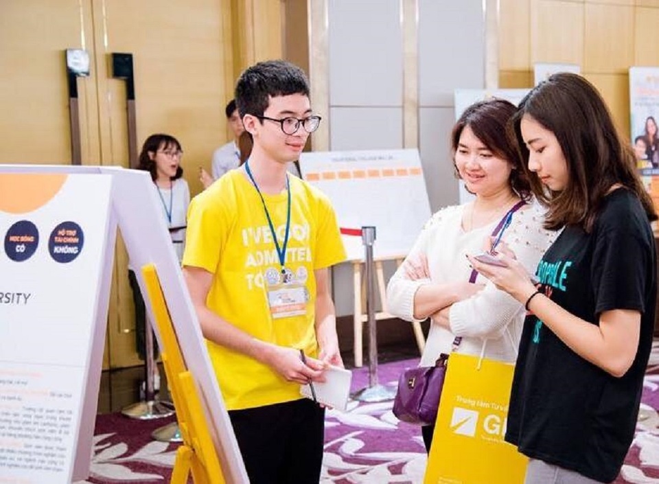 Vì sao cần có chiến lược riêng cho từng ngành khi ứng tuyển đại học Mỹ? - 1 Du học sinh Việt đang học tại Mỹ (áo vàng) chia sẻ bí quyết giành học bổng cho người tham dự triển lãm.