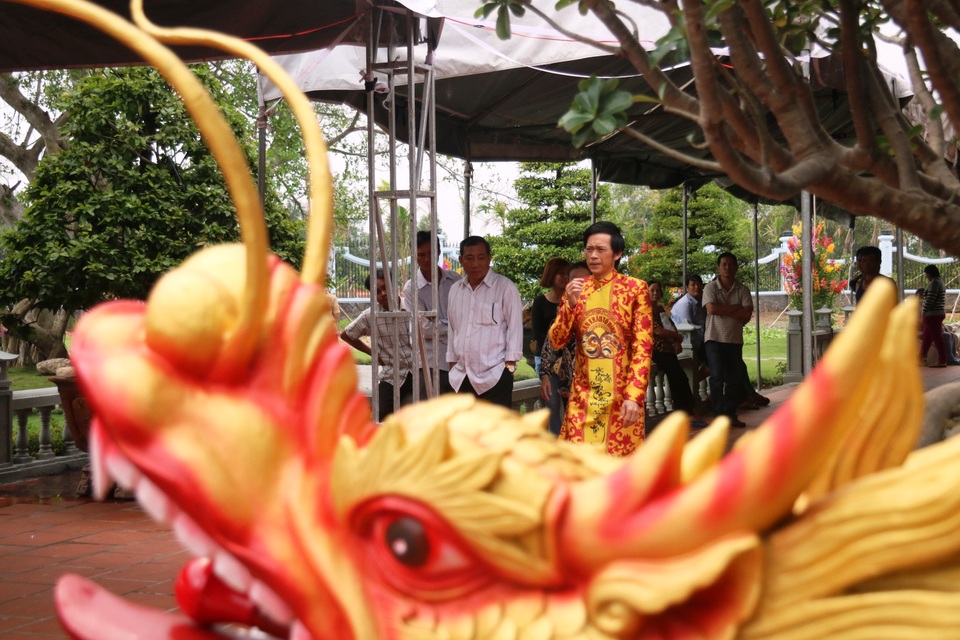 Nam danh hài mặc chiếc áo dài truyền thống niềm nở đón khách đến thăm Đền.