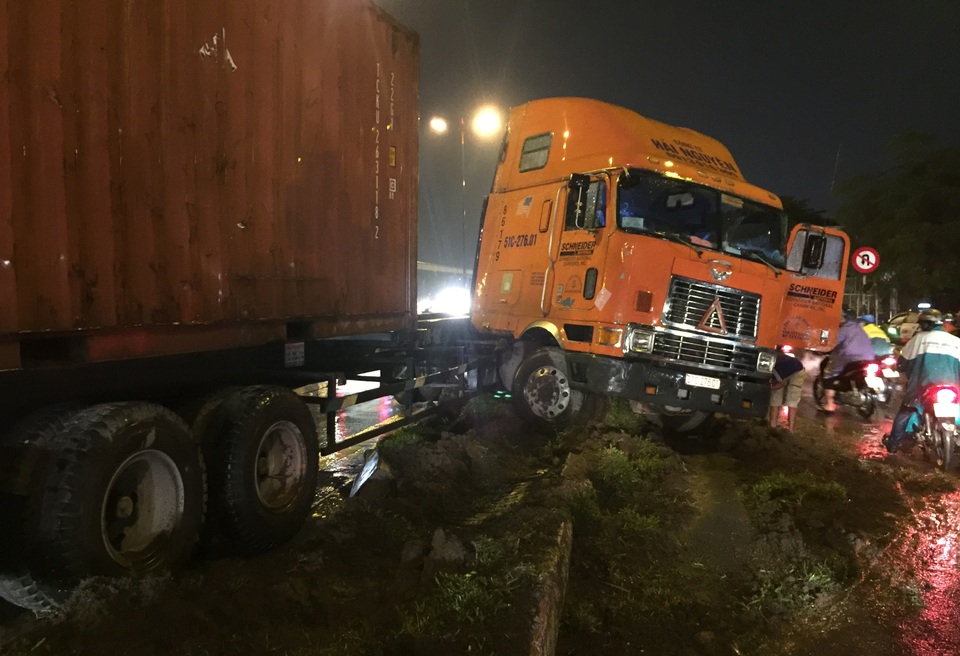 Chiếc xe đầu kéo container đang đổ dốc cầu Rạch Chiếc trên XLHN trong cơn mưa lớn, bất ngờ mất lái, lao lên dải phân cách...