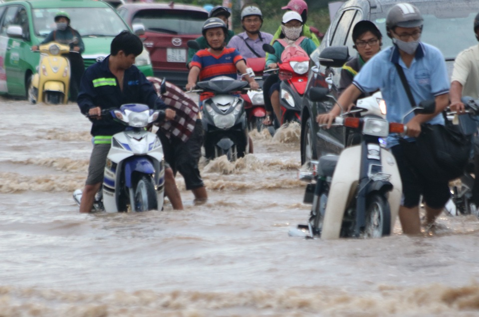 Người dân ì ạch dắt xe khỏi vùng ngập nặng trên đường Lương Định Của, quận 2.