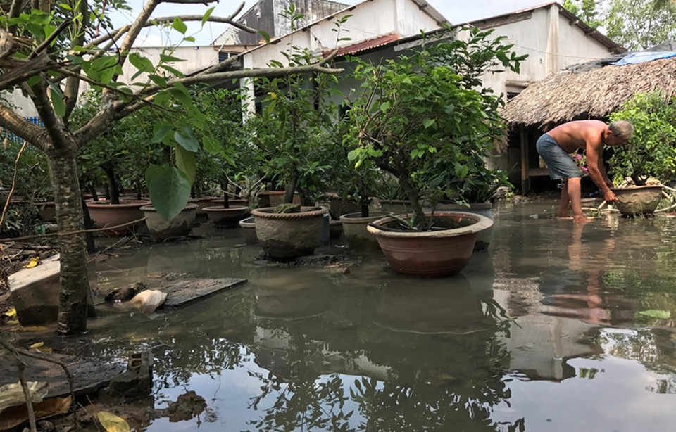 
Một hộ dân bị thiệt hại sau vụ vỡ đê bao sông Sài Gòn đang thu dọn.
