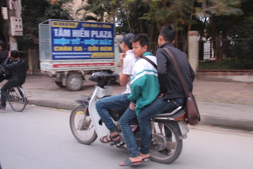 Thậm chí nhiều em học sinh đi xe máy kẹp 3, đầu trần nghênh ngang trên đường như thế này