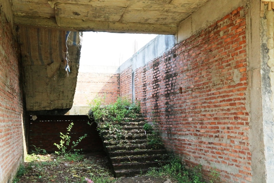 Cầu thang, tường bị rêu mốc, cỏ dại bám đầy