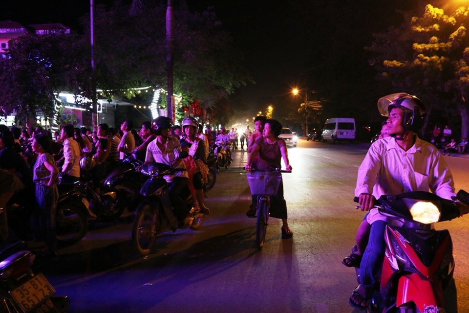 Người dân đi đường cũng dừng lại ngó vào xem các nghệ sĩ biểu diễn.