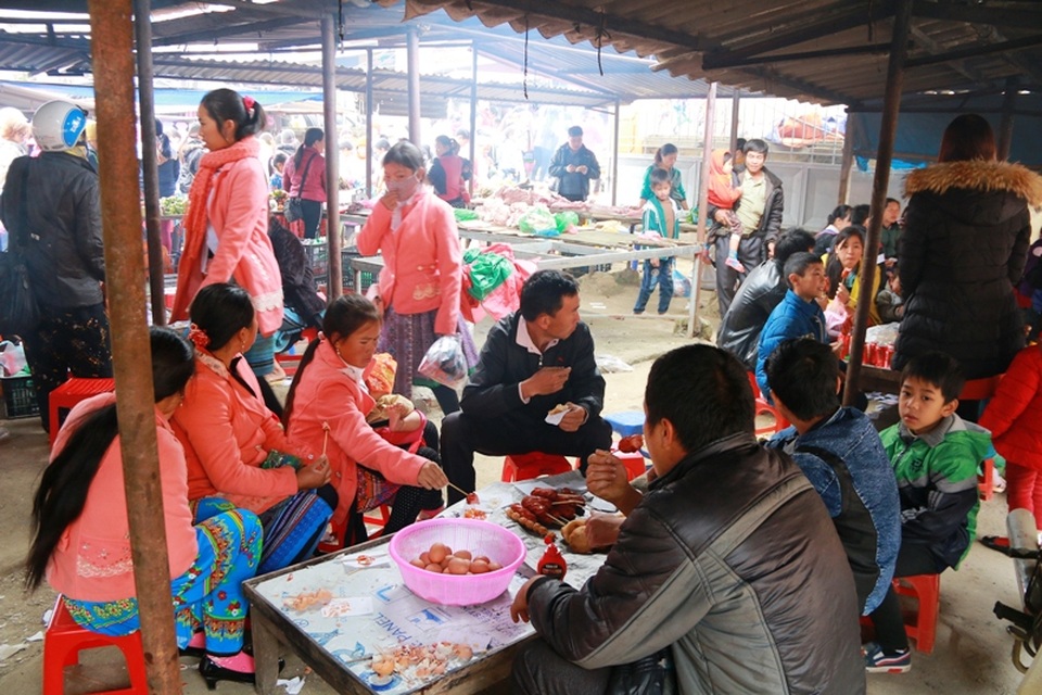 Nhiều người đi chợ sắm Tết, tranh thủ ghé vào một hàng ăn vặt để giải lao. Xúc xích, bánh rán, thịt nướng là những món ăn được mọi người ưa thích.