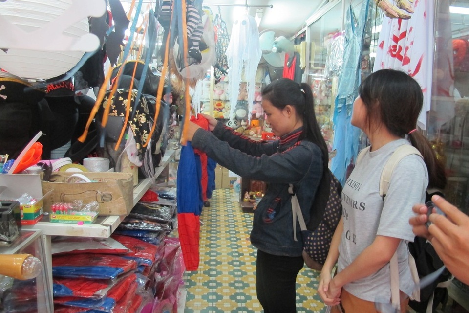 Hai bạn sinh viên đang chọn đồ để tham gia lễ hội Halloween