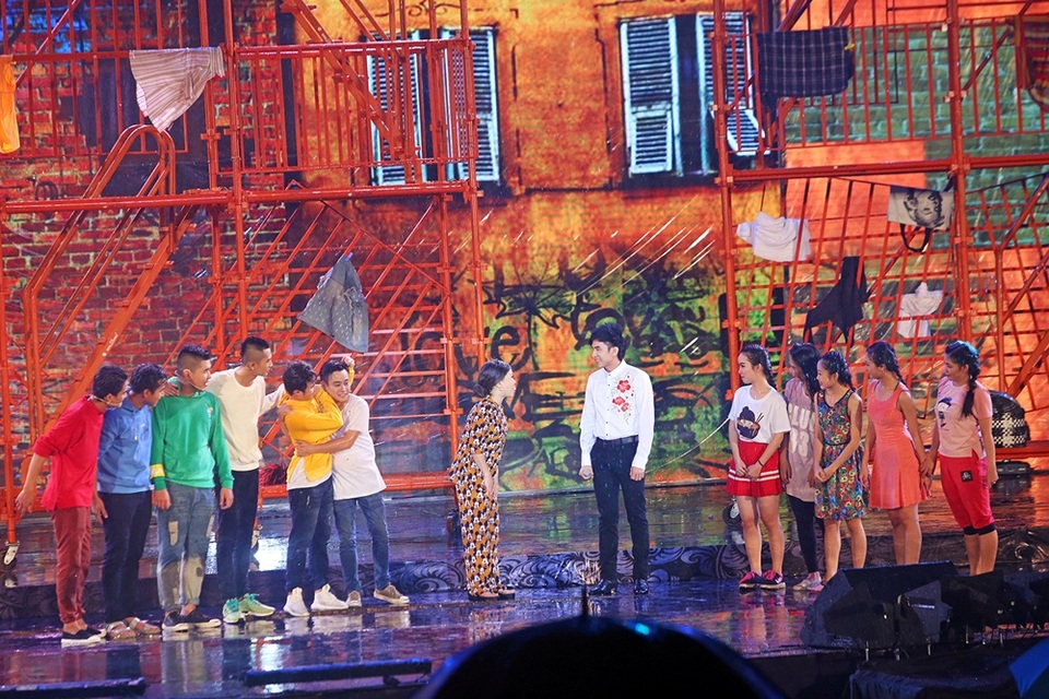 Đan Trường hóa thân thành thầy giáo, diễn một đoạn ngắn trong tiểu phẩm và kết hợp trình diễn cùng 100 vũ công.