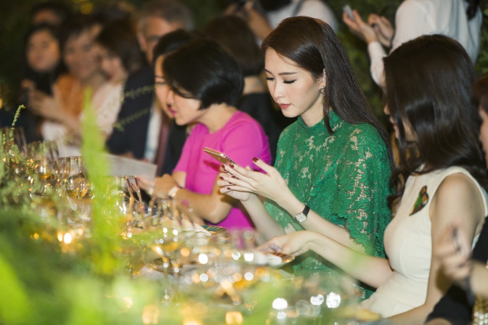 Thỉnh thoảng trong buổi tiệc người đẹp lại nghịch điện thoại, nhưng vẫn thể hiện sự dịu dàng và đáng yêu.