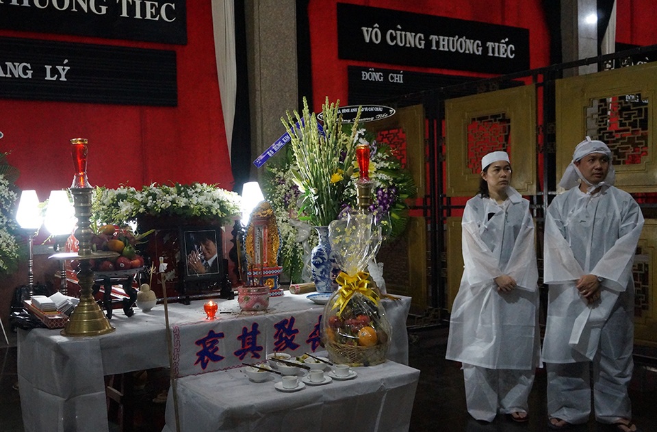 Vợ chồng con trai trưởng của ca sĩ Quang Lý bên linh cữu của cha. Dù rất đau lòng nhưng anh vẫn nén nỗi đau để lo tang lễ cho cha